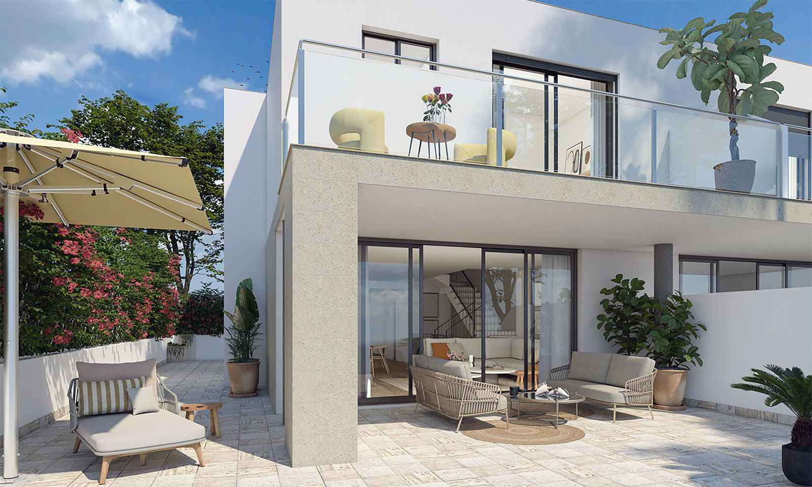 Modern patio with lounge furniture, glass doors, and balcony overlooking a sunny outdoor space.